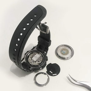 G-SHOCK 腕時計の古い腕時計電池を外し慎重に新しい腕時計電池を取り付けている様子