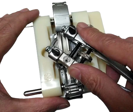 腕時計電池交換修理が必要なオレオール AUREOLEの時計をスクリューバックオープナーを使って丁寧に裏蓋を開けている様子