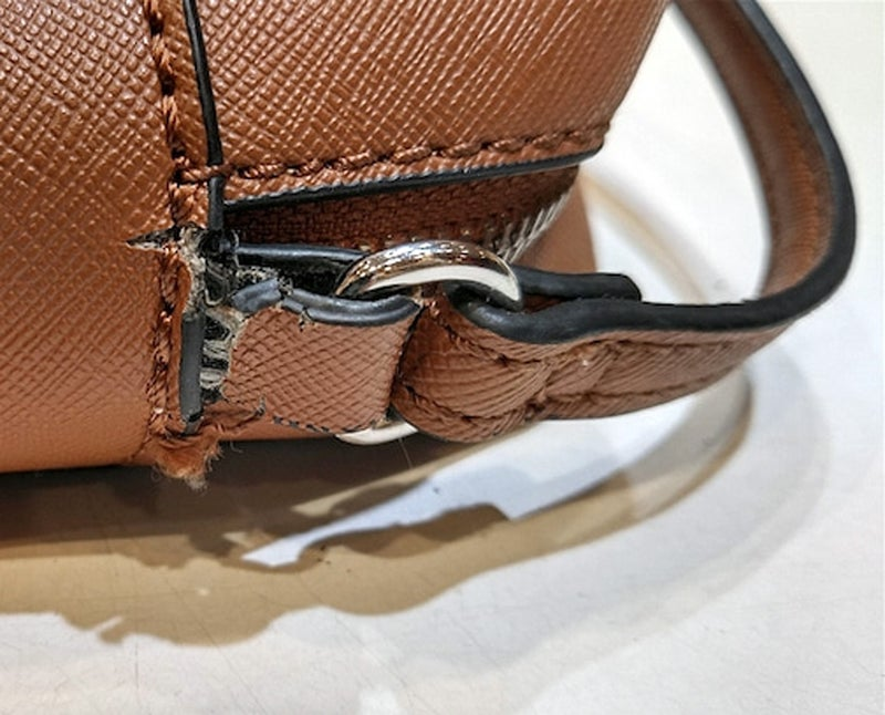 カバン・バック修理前の、ベルトと鞄を繋いでいる所が千切れそうな破損状態